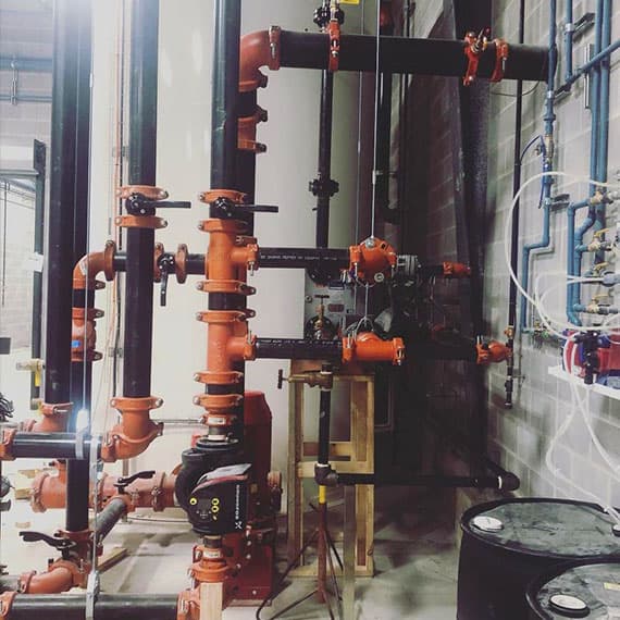 Industrial plumbing manifold with red ball valves